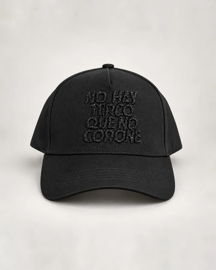 La gorra negra NO HAY TERCO QUE NO CORONE de frente, con la frase bordada en negro en 3D, sobre fondo gris claro